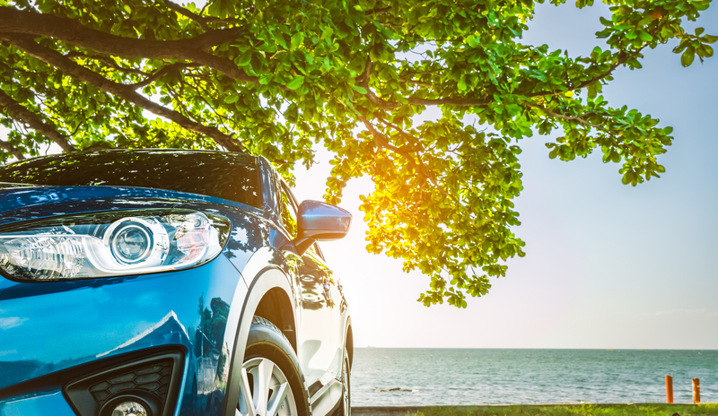Blue vehicle side profile in the summer sun and lake