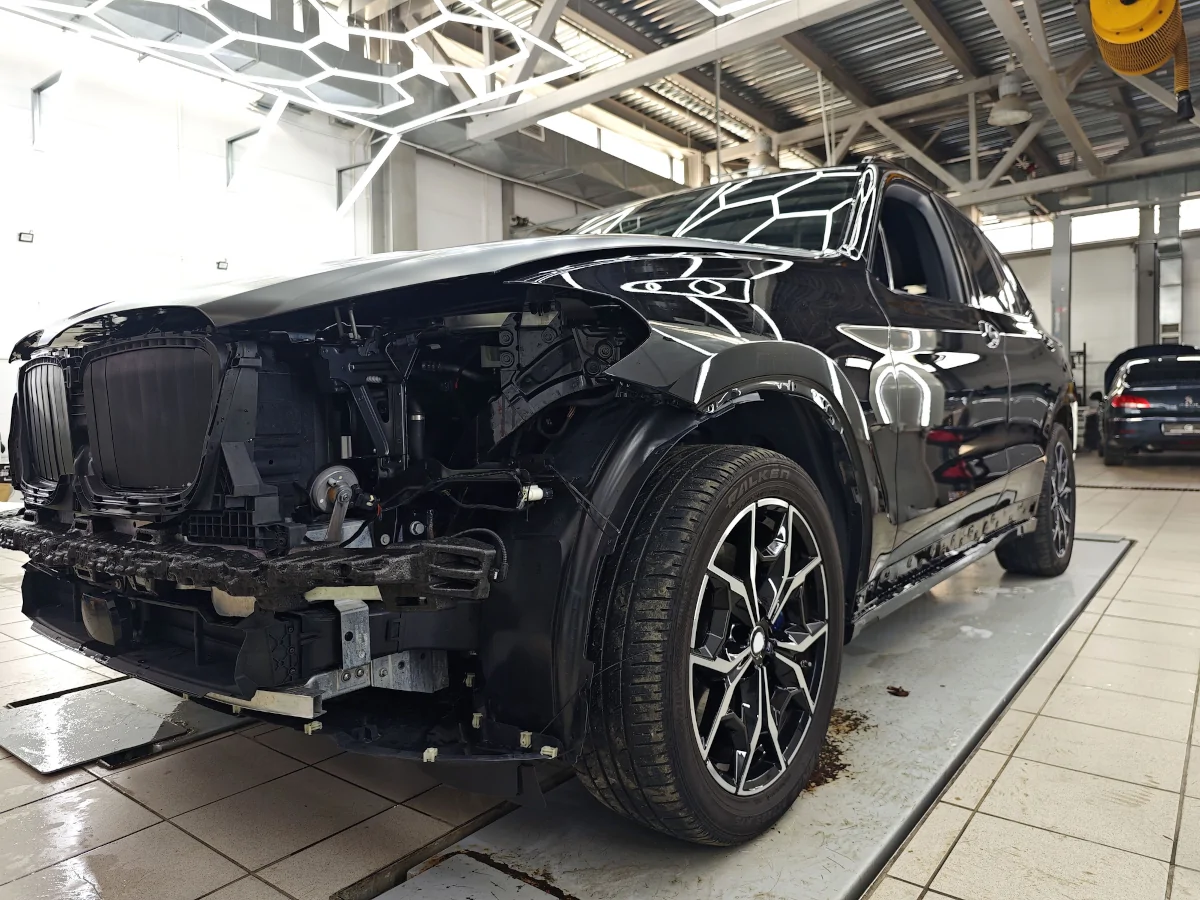 Collision damaged vehicle being inspected at an auto body shop in Lewisville TX