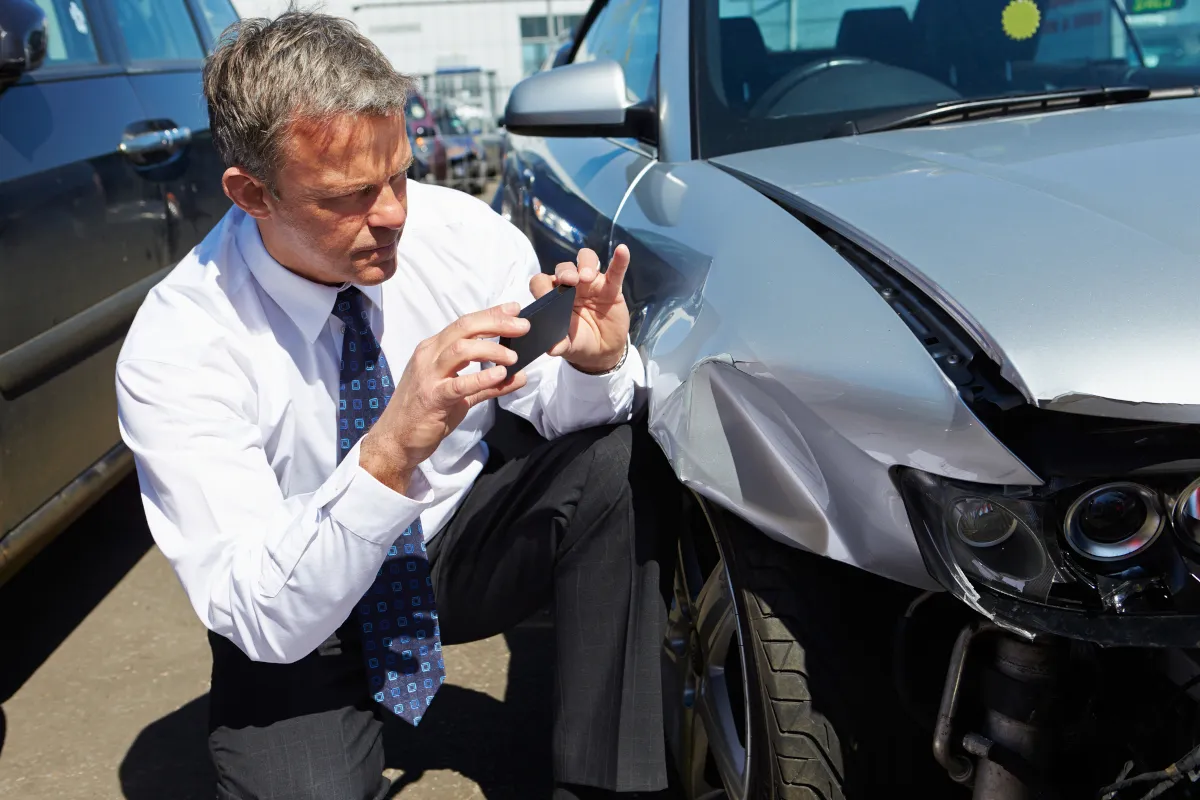 Claims adjuster reviewing damaged vehicle in Lewisville, TX