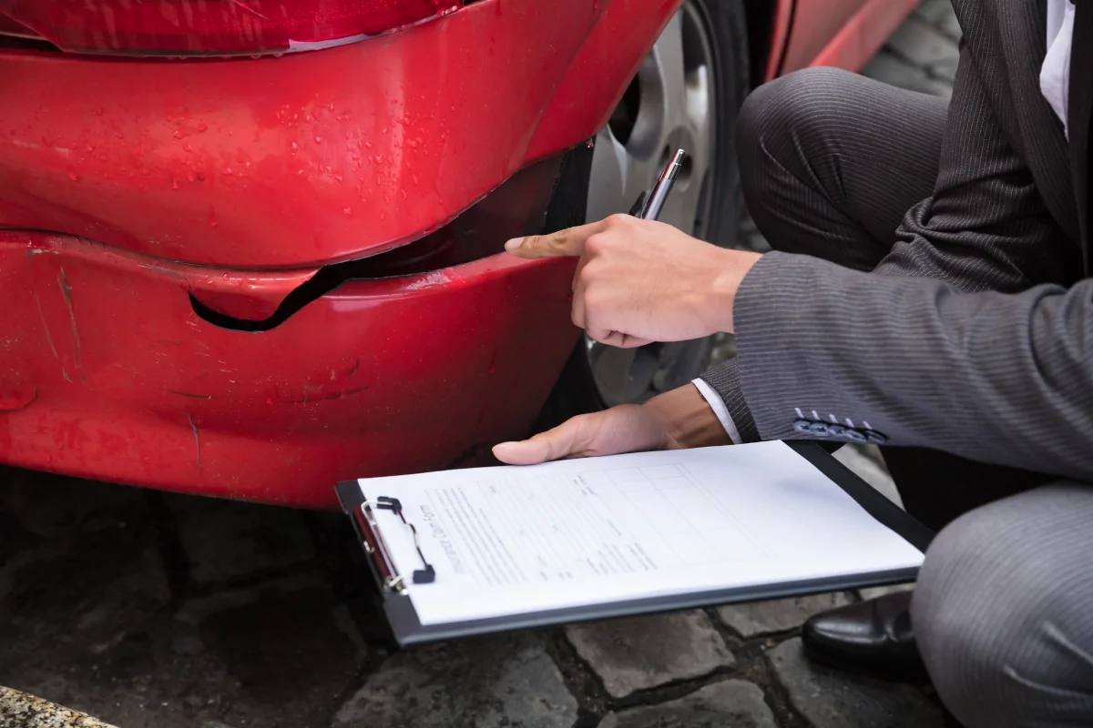Auto body repair estimate and insurance claim paperwork for a damaged vehicle
